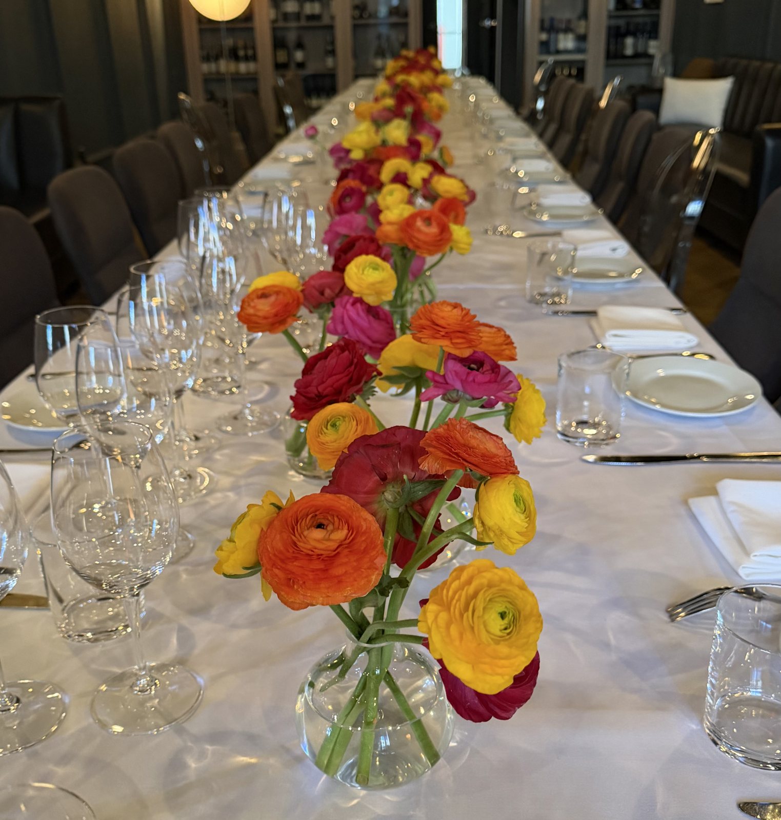 Ranunculus bud vases along a private dining table